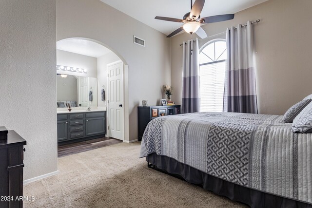 carpeted bedroom with connected bathroom and ceiling fan