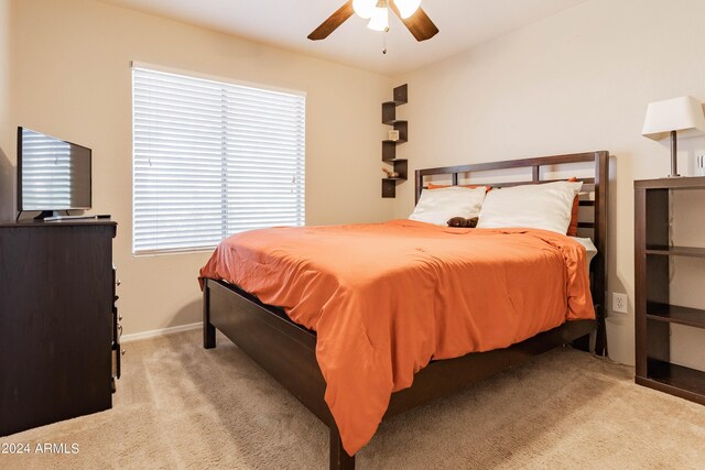 carpeted bedroom featuring multiple windows and ceiling fan