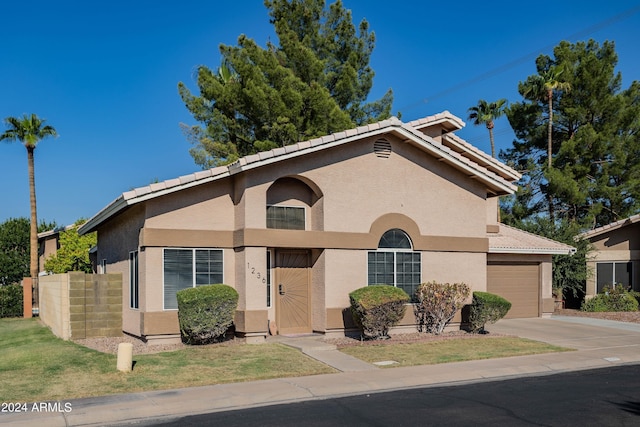 view of front of house featuring stucco siding, a tiled roof, concrete driveway, and a garage