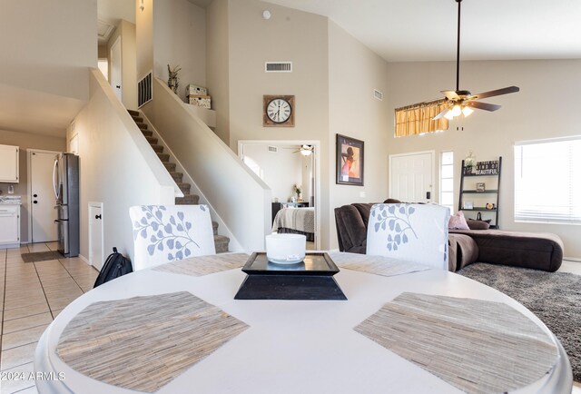 dining room featuring ceiling fan, high vaulted ceiling, and light tile patterned flooring