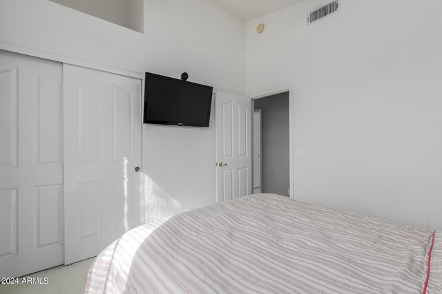 bedroom featuring light colored carpet and a closet