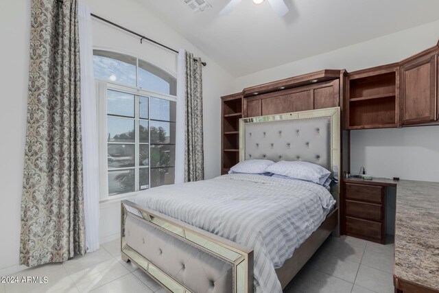 tiled bedroom with lofted ceiling and ceiling fan