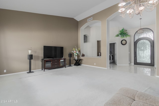 carpeted living room with washer / clothes dryer, an inviting chandelier, and vaulted ceiling