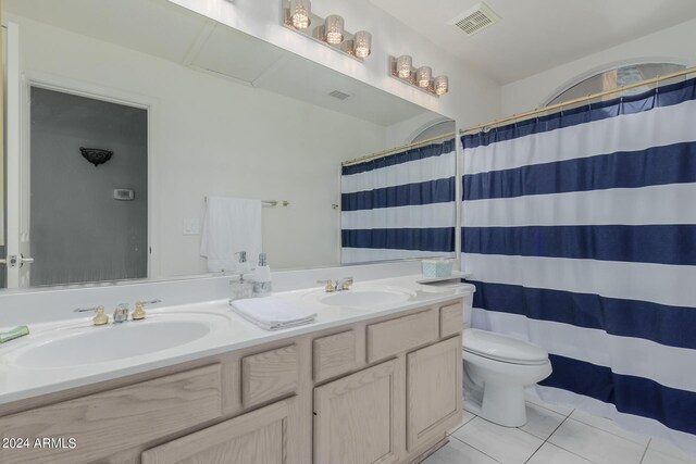 bathroom with tile patterned floors, a shower with curtain, vanity, and toilet