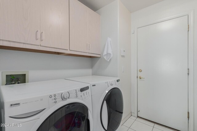 laundry room with light tile patterned flooring, independent washer and dryer, and cabinets