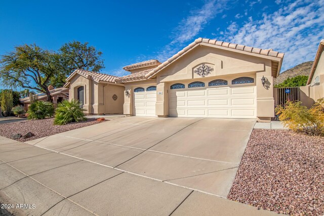 mediterranean / spanish home with a garage