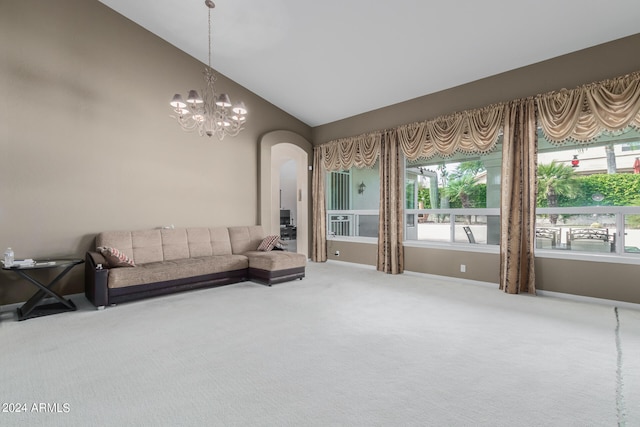 carpeted living room with a notable chandelier and vaulted ceiling