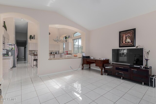 living room featuring lofted ceiling and light tile patterned floors