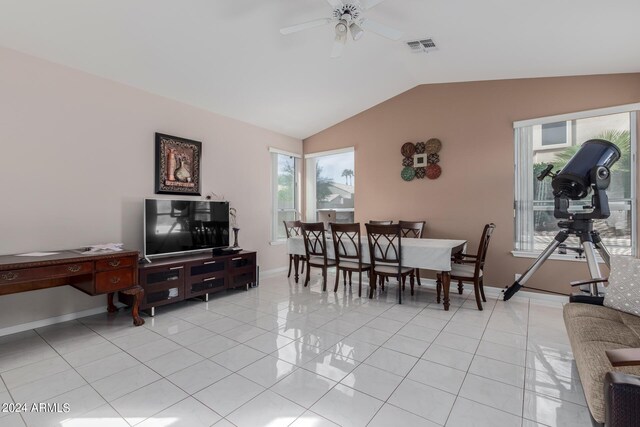 dining room featuring ceiling fan, vaulted ceiling, and light tile patterned floors