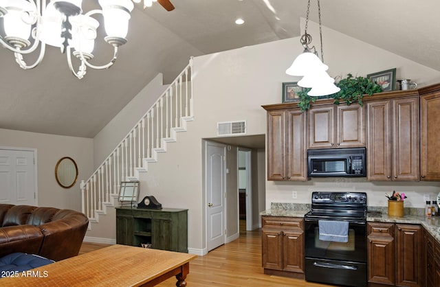 kitchen with black appliances, light stone countertops, a notable chandelier, light hardwood / wood-style flooring, and lofted ceiling