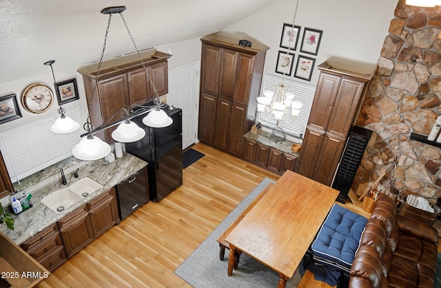 kitchen featuring sink, light wood-type flooring, and decorative light fixtures