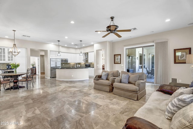 living area with recessed lighting, visible vents, and ceiling fan with notable chandelier