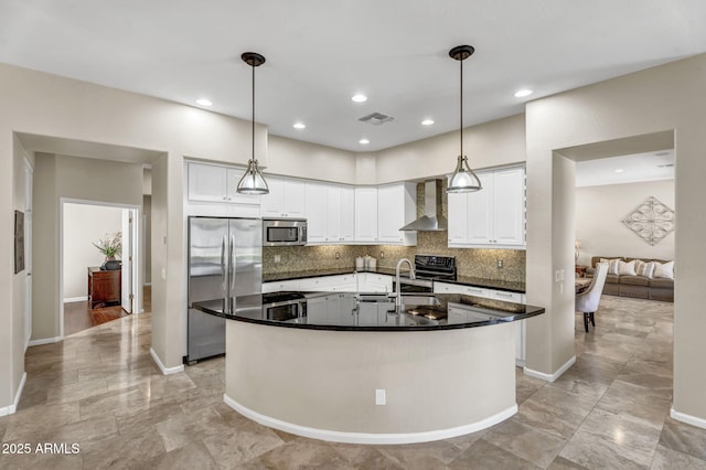 kitchen with stainless steel appliances, a sink, visible vents, wall chimney range hood, and dark countertops