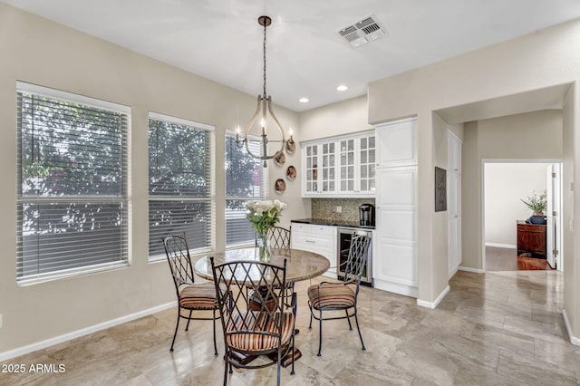 dining area with beverage cooler, a wealth of natural light, visible vents, and baseboards