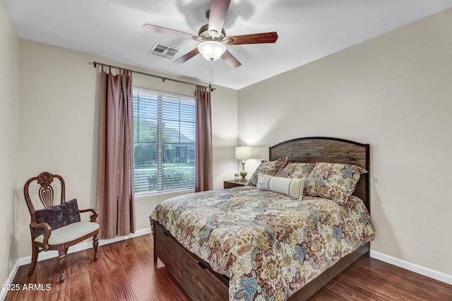 bedroom featuring baseboards, visible vents, ceiling fan, and wood finished floors