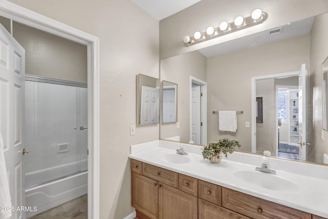 bathroom featuring enclosed tub / shower combo, a sink, visible vents, and double vanity