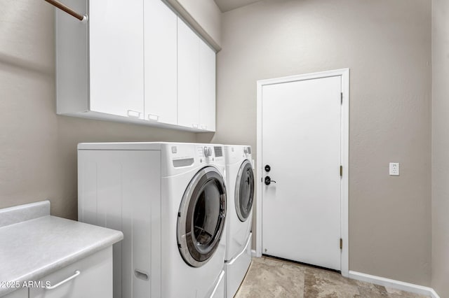 washroom with independent washer and dryer, cabinet space, and baseboards