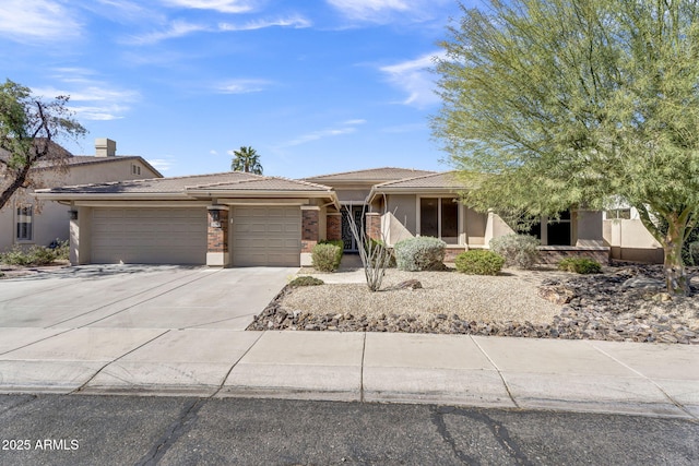 view of front of property featuring a garage, driveway, a tiled roof, and stucco siding