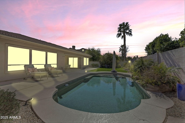 pool at dusk featuring a patio area, a fenced backyard, and a fenced in pool