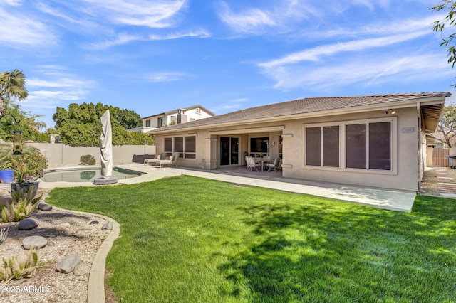 back of house featuring a fenced backyard, a lawn, a patio, and stucco siding