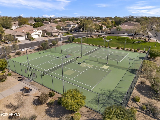 view of sport court with a residential view, fence, and a yard