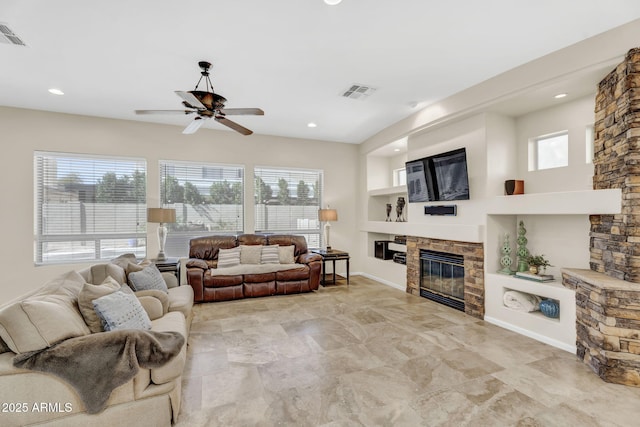 living area featuring built in features, a wealth of natural light, visible vents, and a fireplace