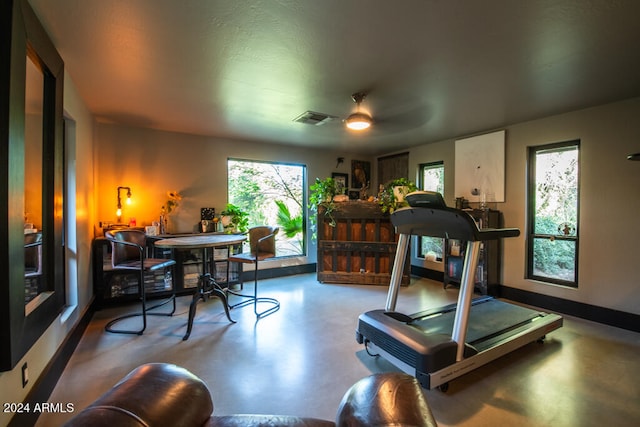 workout room featuring ceiling fan and concrete flooring