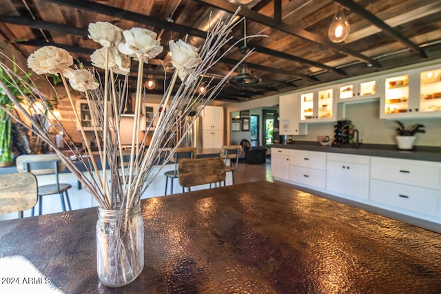 unfurnished dining area with beamed ceiling and wooden ceiling