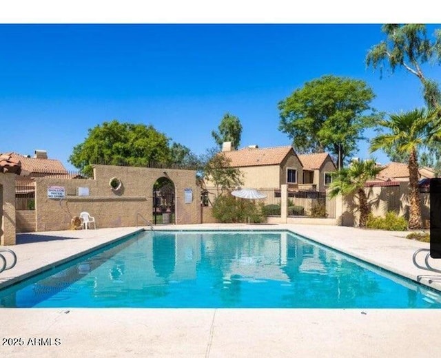 community pool featuring a patio area and fence