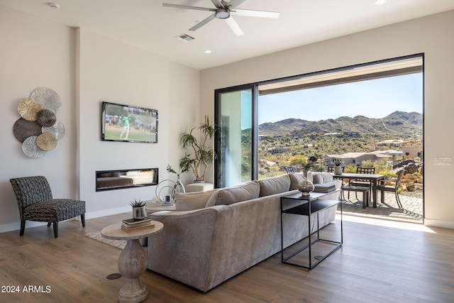 living room featuring ceiling fan and hardwood / wood-style flooring