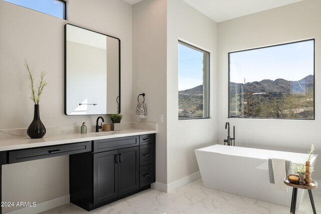 bathroom with a mountain view, vanity, and a bathing tub