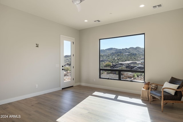 sitting room featuring a healthy amount of sunlight, a mountain view, and dark wood-type flooring