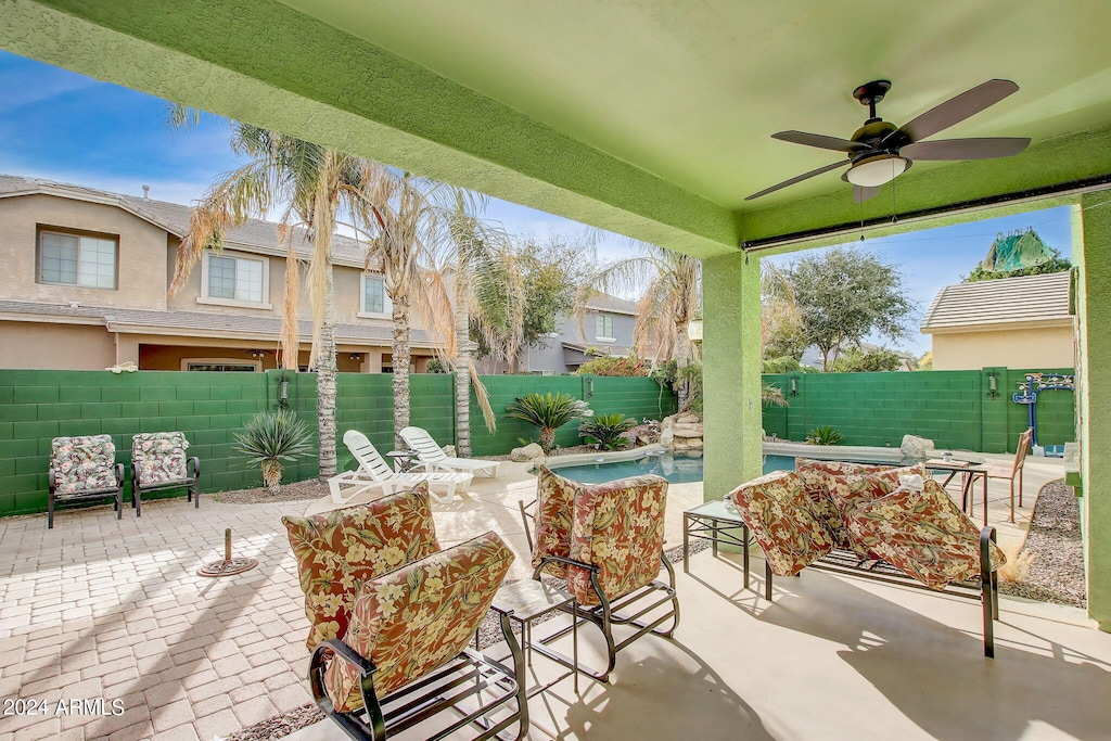 view of patio / terrace with ceiling fan and a fenced in pool