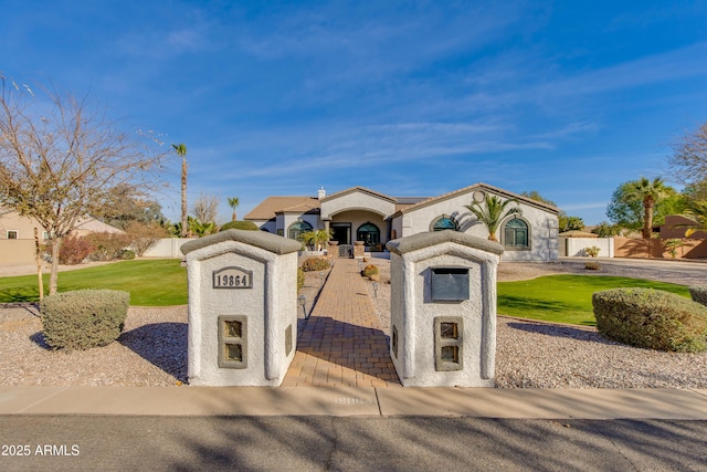 view of front of house featuring a fenced front yard, a front lawn, and stucco siding