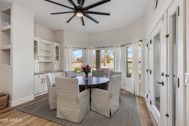 dining room featuring wood finished floors, a ceiling fan, and baseboards