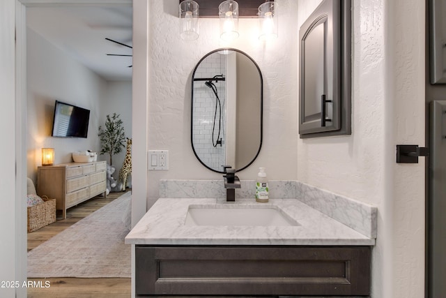 bathroom featuring a textured wall, wood finished floors, and vanity