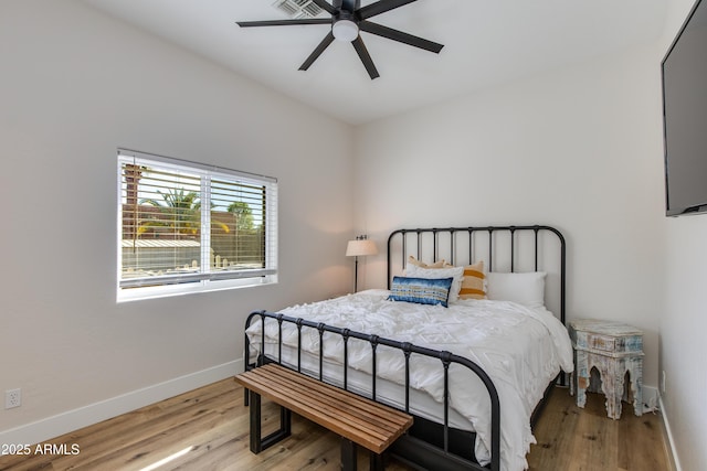 bedroom featuring light wood-type flooring, ceiling fan, and baseboards