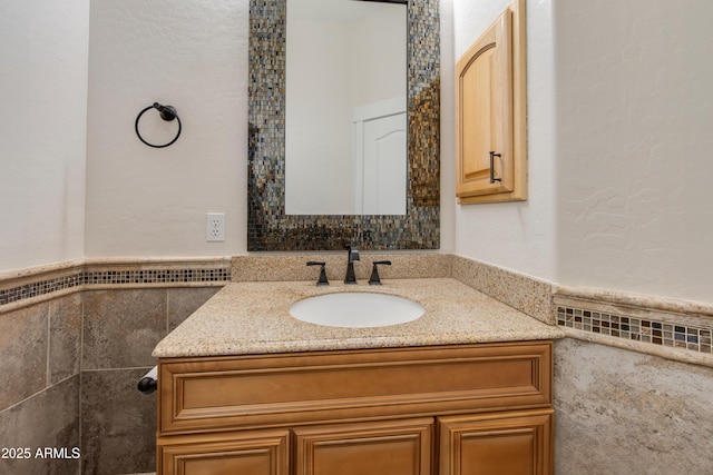 bathroom with wainscoting, tile walls, and vanity