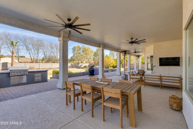 view of patio / terrace featuring an outdoor kitchen, a fenced backyard, a ceiling fan, grilling area, and outdoor dining space