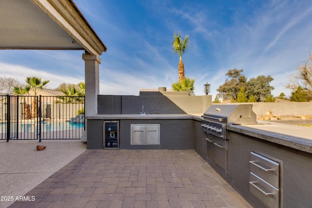 view of patio featuring a fenced in pool, a sink, fence, and area for grilling