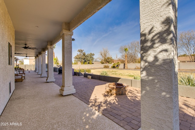 view of patio / terrace featuring an outdoor fire pit, a fenced backyard, and a ceiling fan