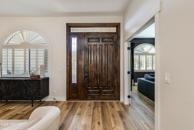 entryway with light wood finished floors and baseboards