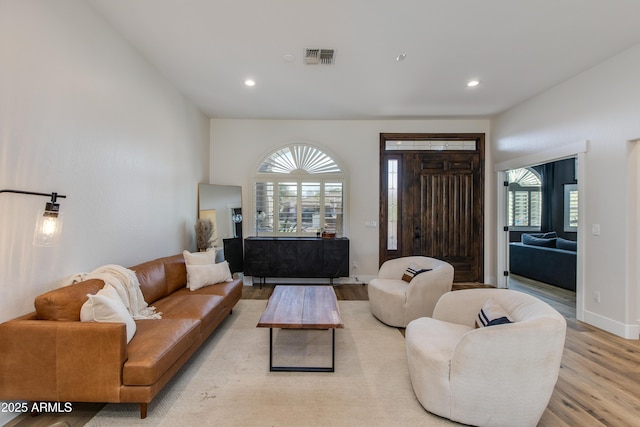 living room with recessed lighting, baseboards, visible vents, and light wood finished floors