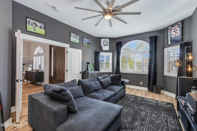 living room with ceiling fan, wood finished floors, and baseboards