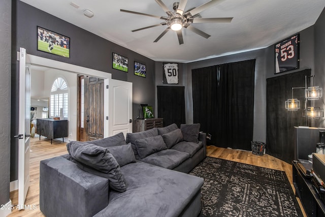 living area featuring a ceiling fan and wood finished floors