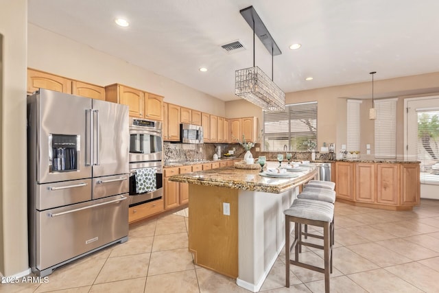 kitchen with light tile patterned flooring, light brown cabinetry, and stainless steel appliances