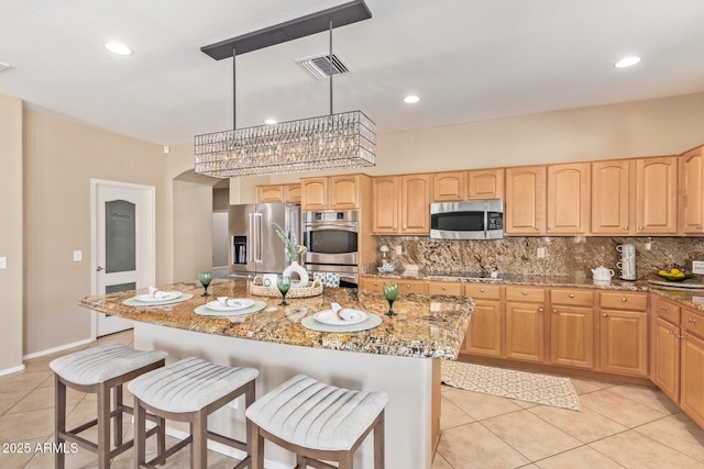 kitchen featuring visible vents, light stone countertops, tasteful backsplash, and appliances with stainless steel finishes