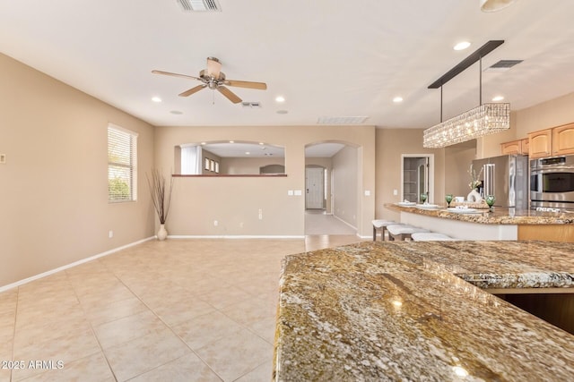 kitchen featuring arched walkways, visible vents, appliances with stainless steel finishes, and ceiling fan