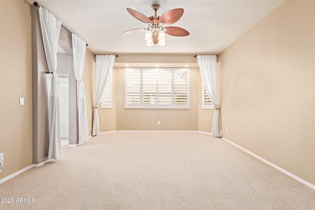 spare room featuring carpet flooring, baseboards, and a ceiling fan