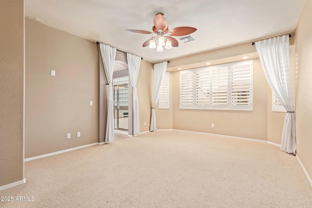 spare room featuring visible vents, baseboards, a ceiling fan, and carpet floors